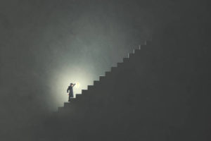 man with lamp rising stairs in the darkness